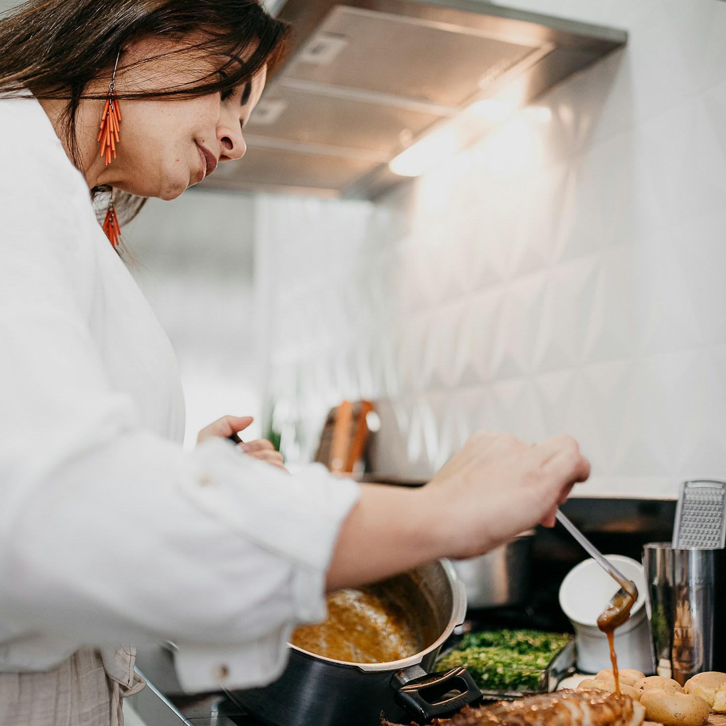 People collaborating in a contemporary kitchen space, exchanging recipes and cooking techniques